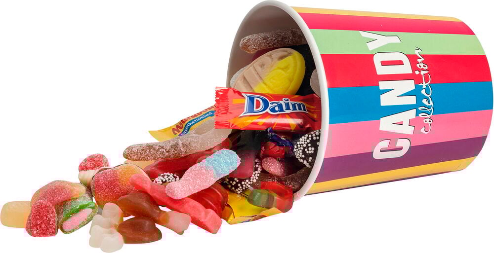 Raidallinen kuppi Makeiset Hultén Candy Collection 450 g, josta valuu erilaisia makeisia, mukaan lukien Daim-patukka.