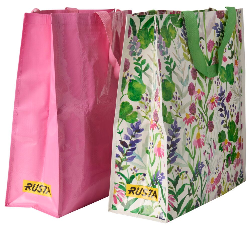 Kukkakuvioinen Ostoskassi Large Kesä vihreillä kahvoilla, sekä pinkki ostoskassi, molemmissa Rusta-etiketit.