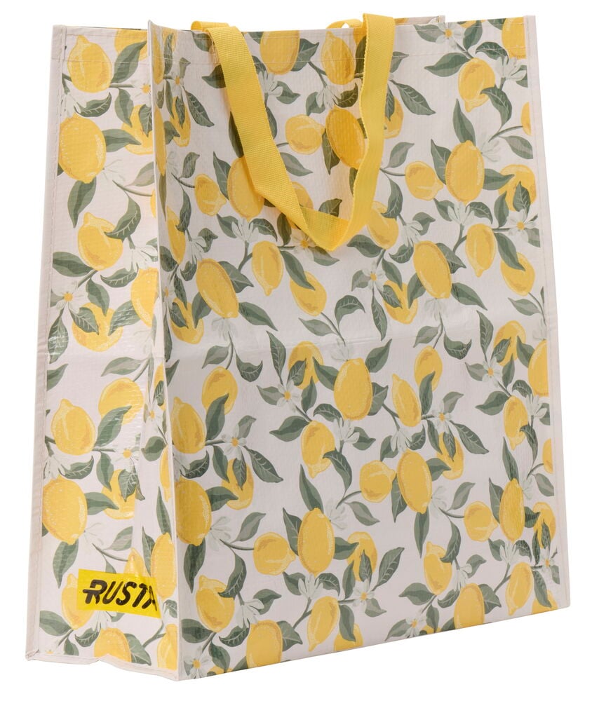 Suuri kesäostoskassi, jossa on eloisa sitruunakuvio vaalealla taustalla ja keltaiset kahvat.