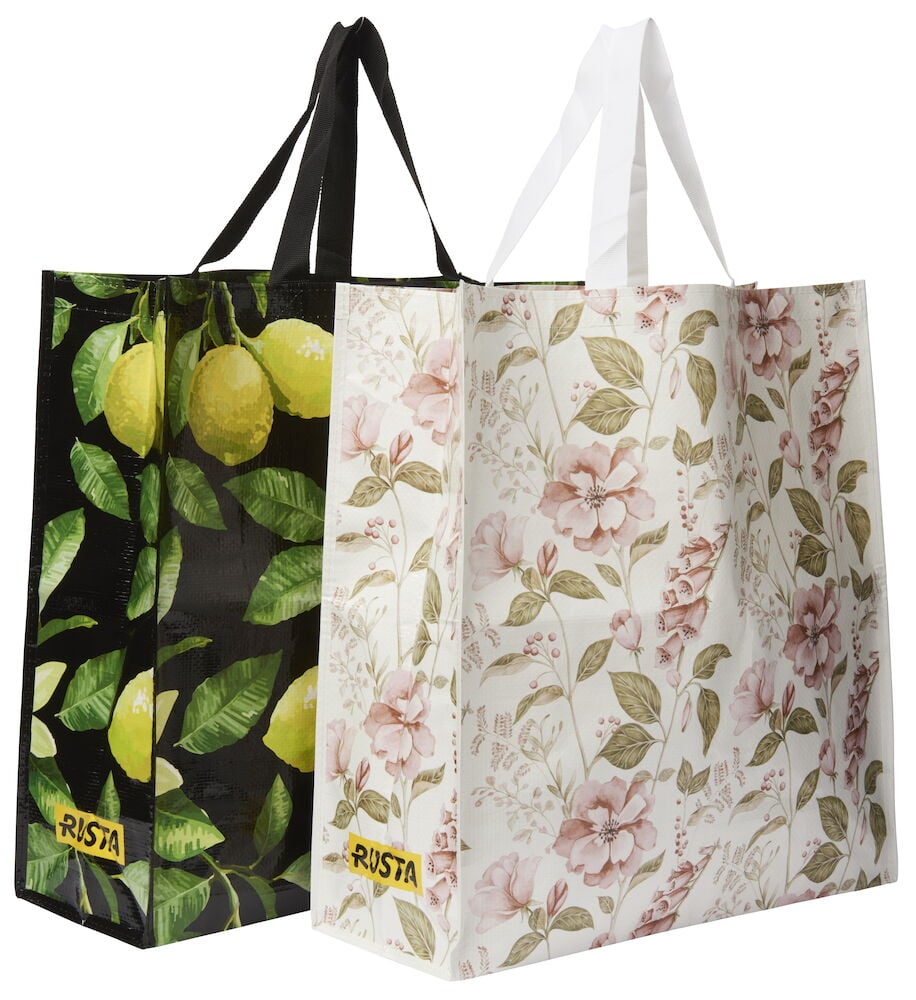 Handlepose Large Spring, en hvit blomstret pose og en svart sitronmønstret pose med håndtak.