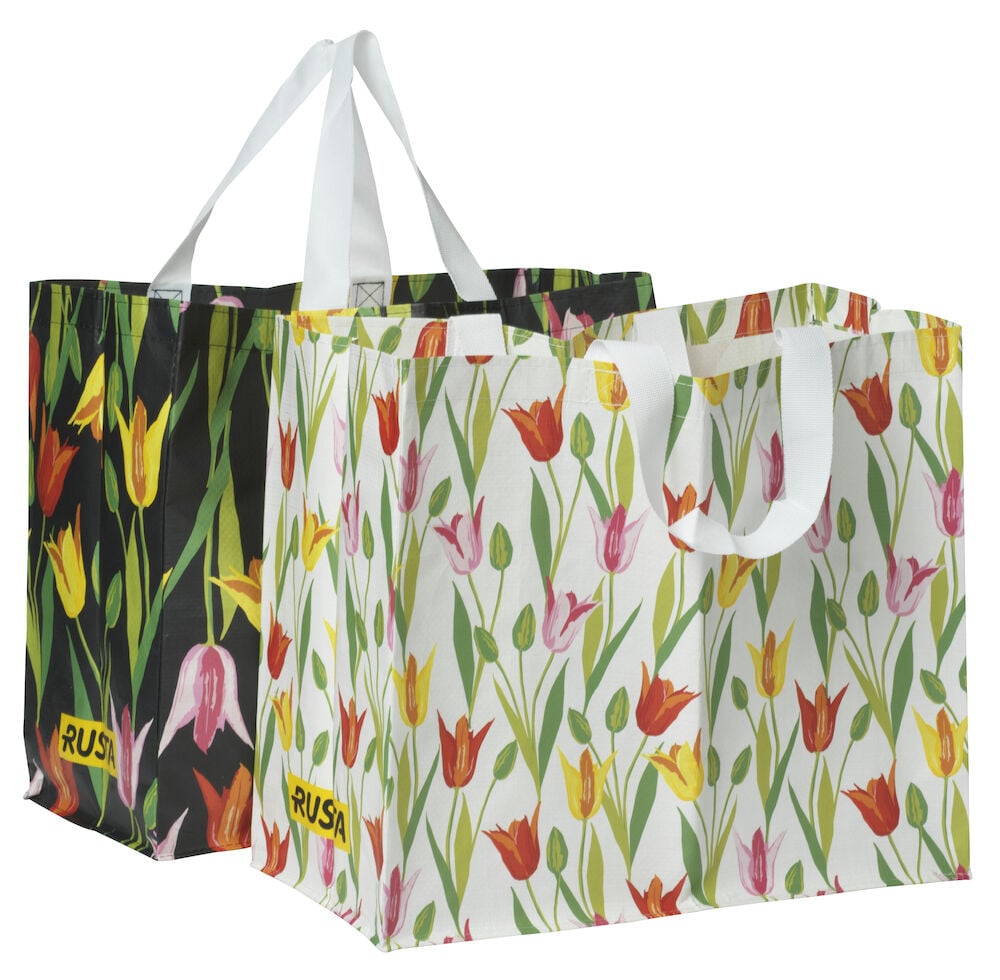 Ostoskassi Medium Kevät valkoinen tulppaanikuviolla, musta tulppaanikuviollinen kassi takana.