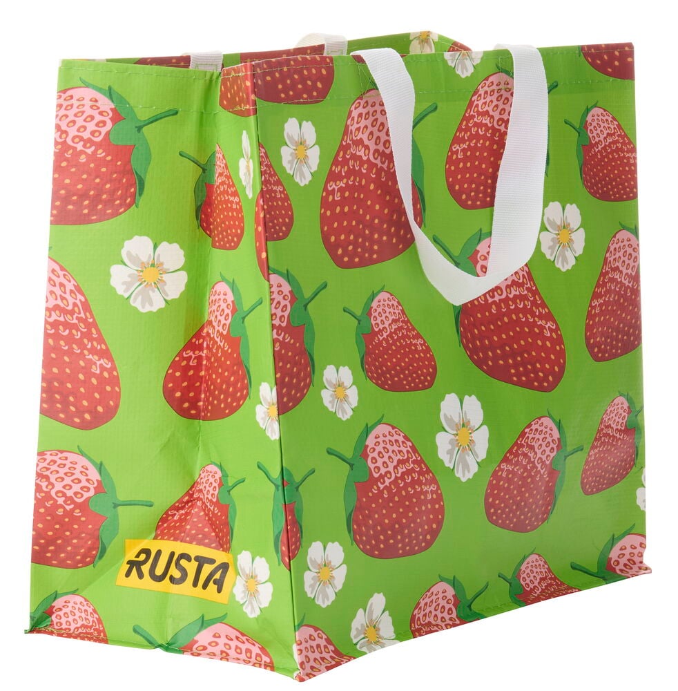 Ostoskassi Medium Kesä: Vaaleanvihreä kangaskassi, jossa punaisia mansikoita ja valkoisia kukkia, valkoiset kahvat.