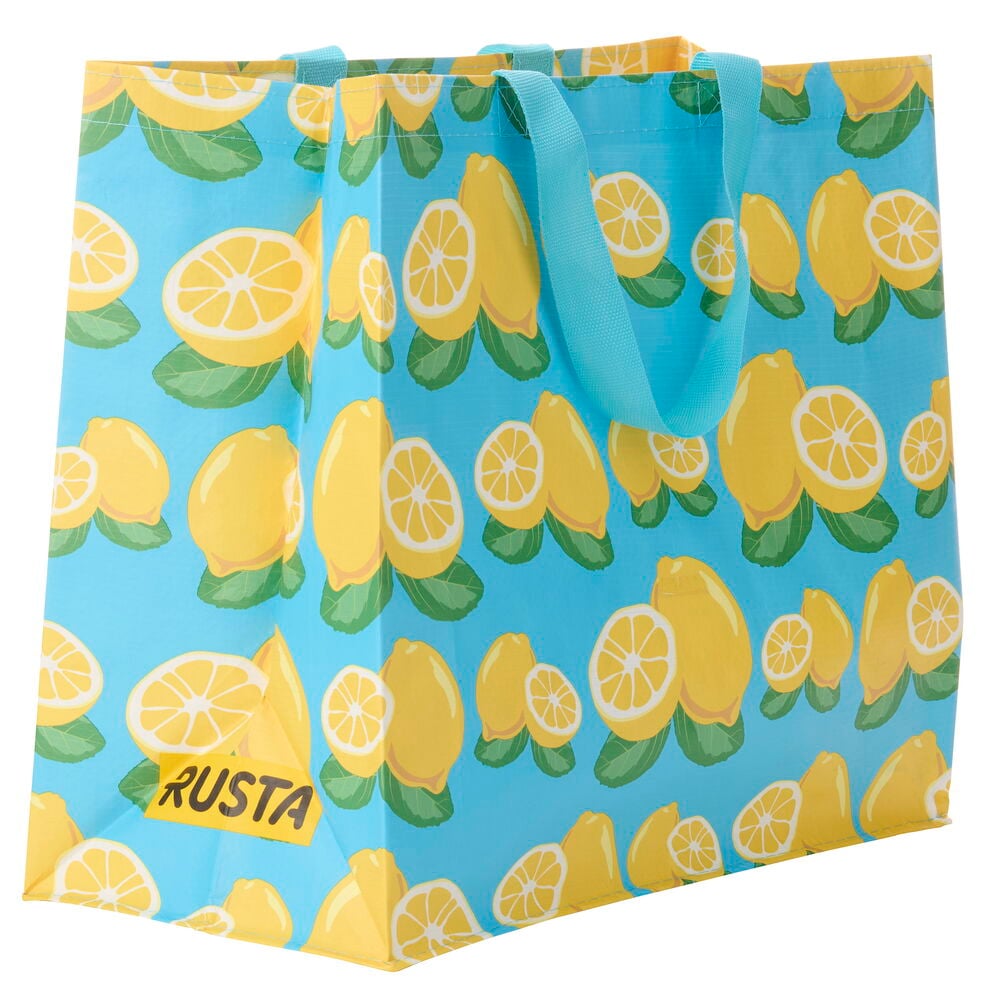 Vaaleansininen Ostoskassi Medium Kesä keltaisella sitruunakuviolla ja sinisillä kahvoilla esitetty.