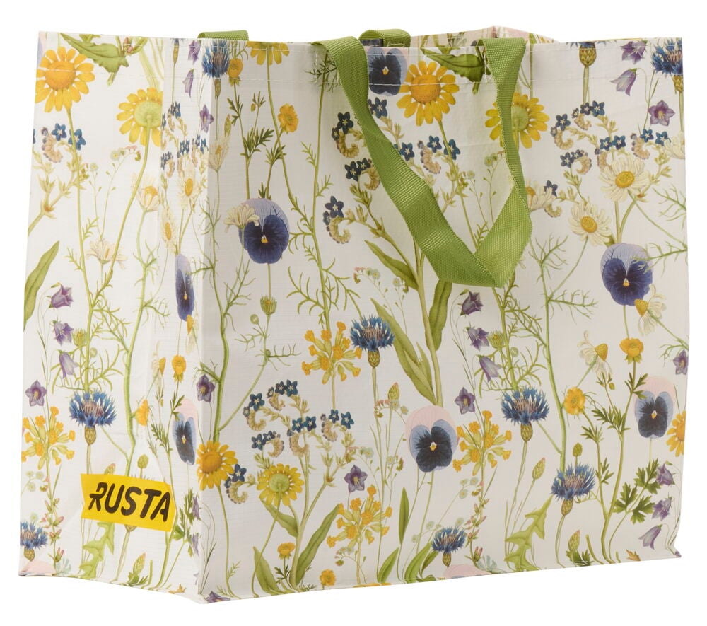 Einkaufstasche mit grünen Griffen und sommerlichem Blumenmuster.