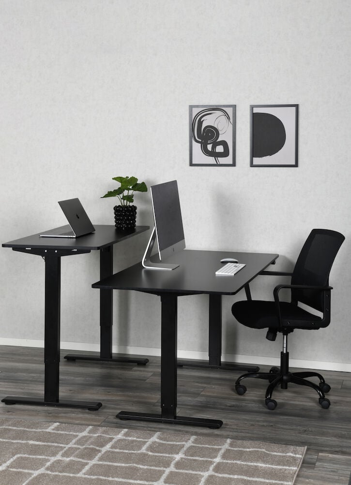 Zwei schwarze Schreibtische mit Computern und Bürostuhl.