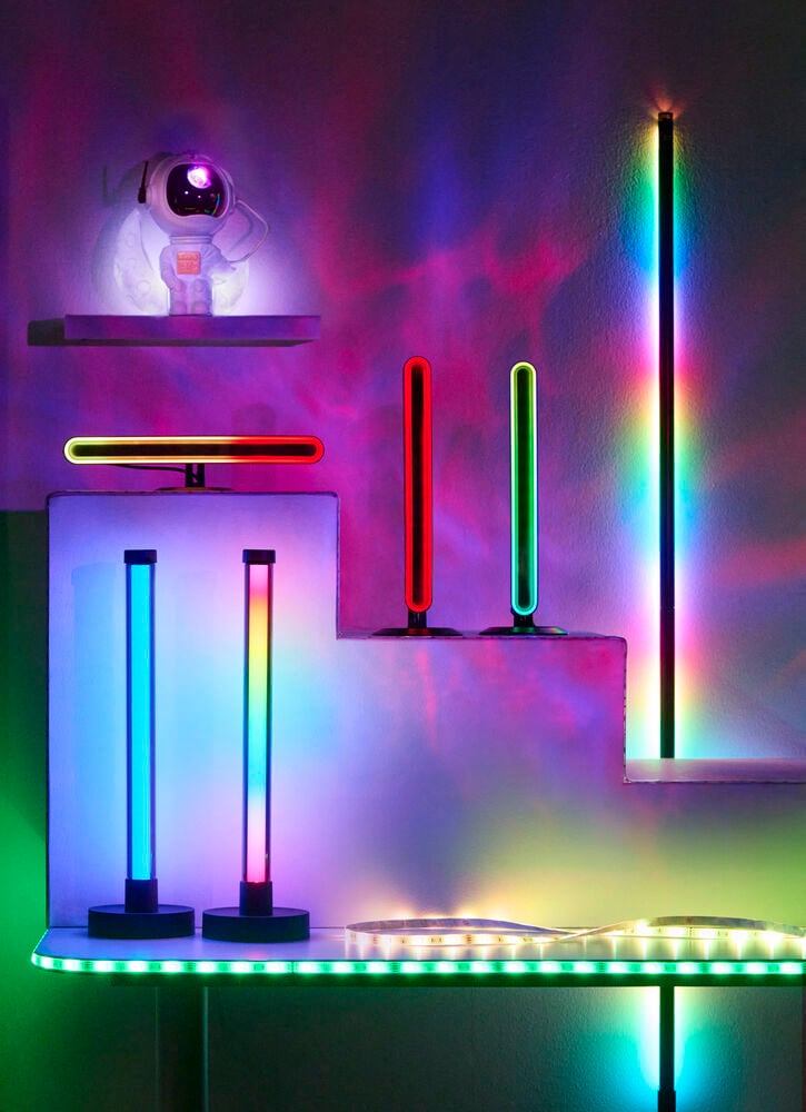 En lång svart Golvlampa LED Ambiance Flerfärgad visar regnbågsljus, med olika färgglada LED-lampor och ljuslister.