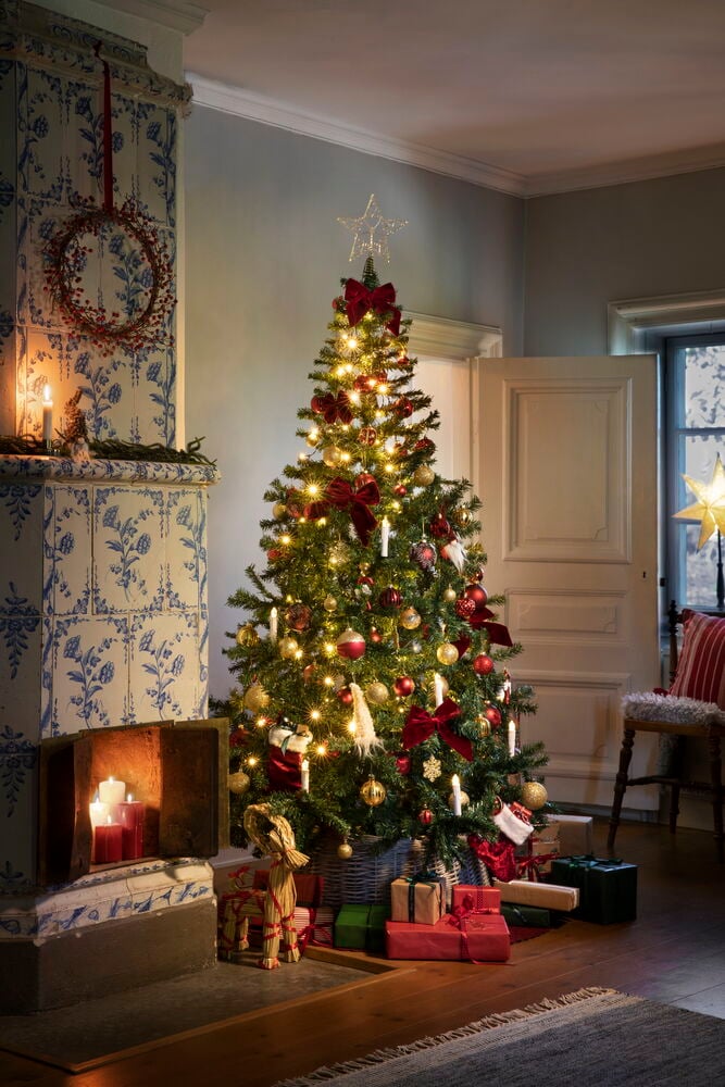 Ein Weihnachtsbaum mit Beleuchtung und roten Dekorationen.