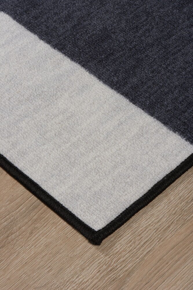 Hörnet av svart och ljusgrå tuftad matta.