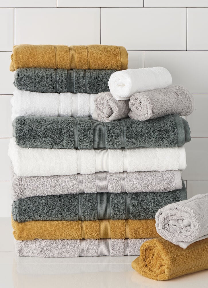 En vikt vit handduk på hög med andra färger.