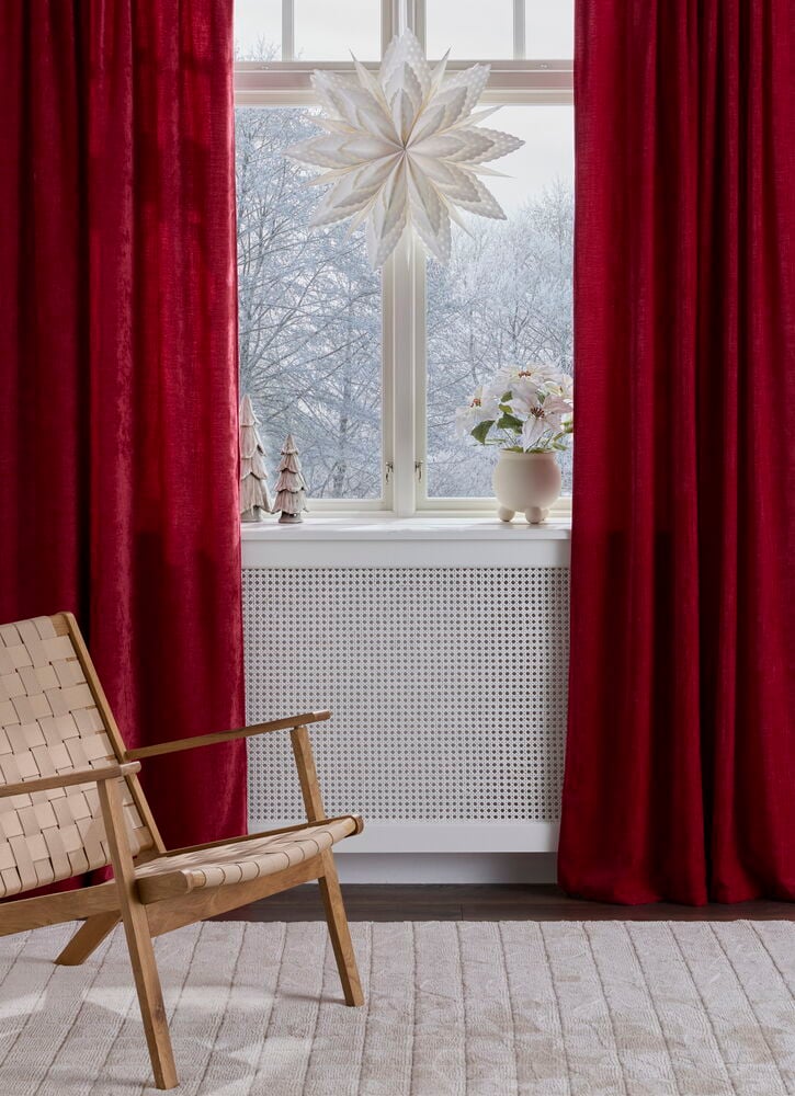 Rote Polyestersamt Vintage Vorhänge rahmen ein Fenster mit Winterlandschaft und weißer Sterndekoration.