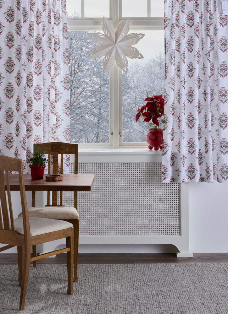 Gardinlengder Astrid 110x160 cm Off-white Bomull 2-pakning med rødt og grønt mønster ved et vindu.