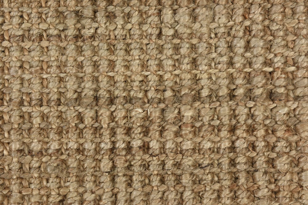 Käsinkudottu juuttimatto hiekanvärisenä.