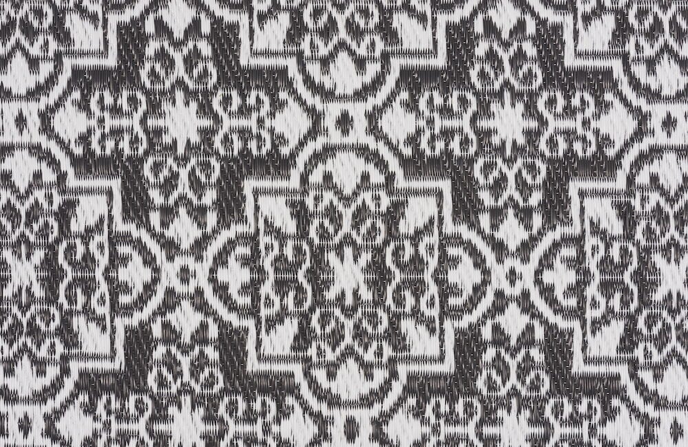 Mönstrad antracitgrå och vit bastmatta i polypropen.