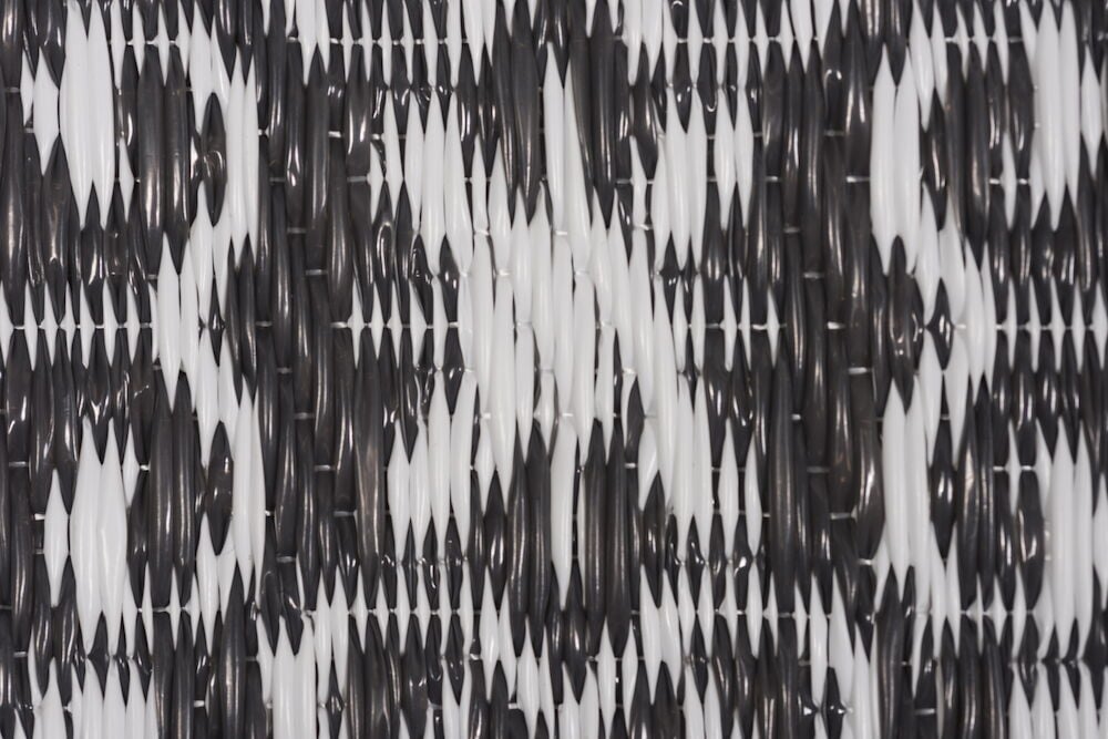 Mönstrad bastmatta i antracit och vitt polypropen.