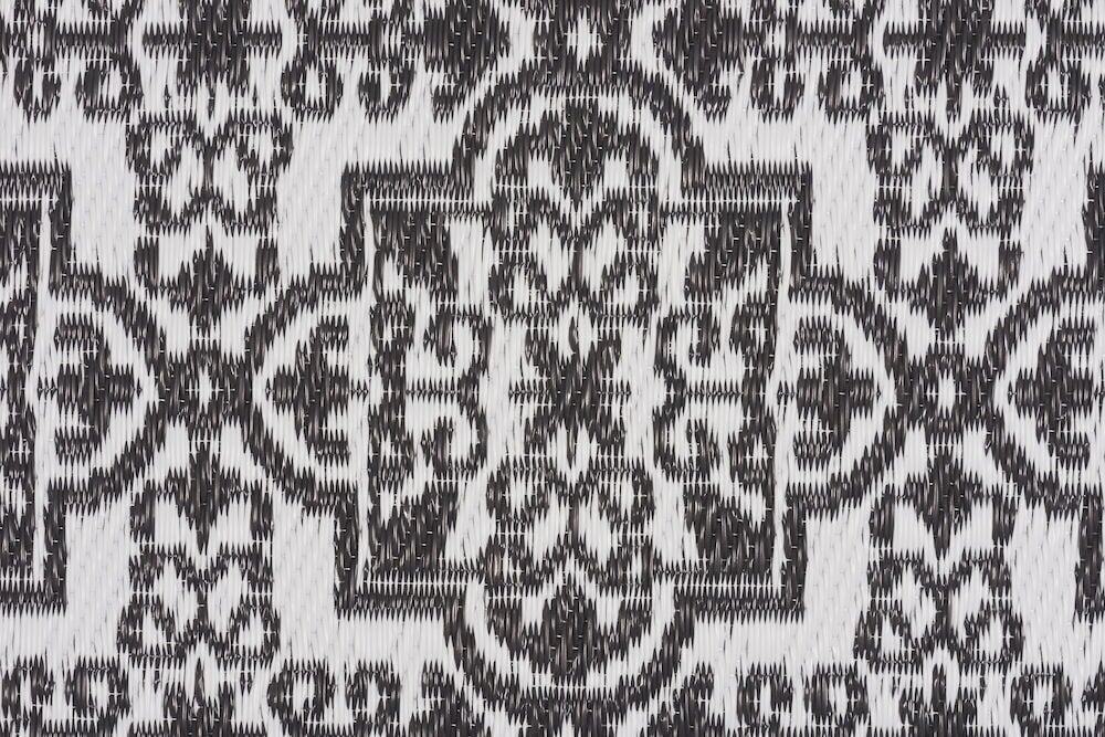 Närbild av bastmatta i antracit med mönster.