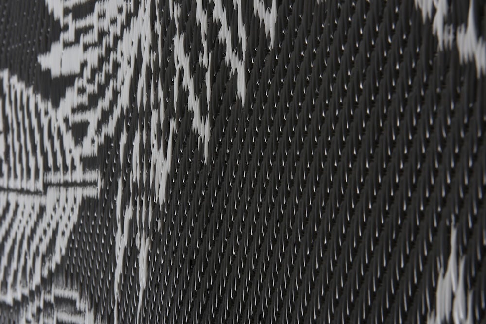 Närbild av svartvit polypropen bastmatta med mönster.