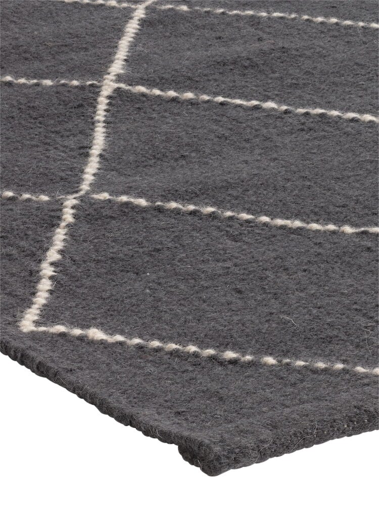 Mörkgrå ullmatta med vita rutiga linjer.