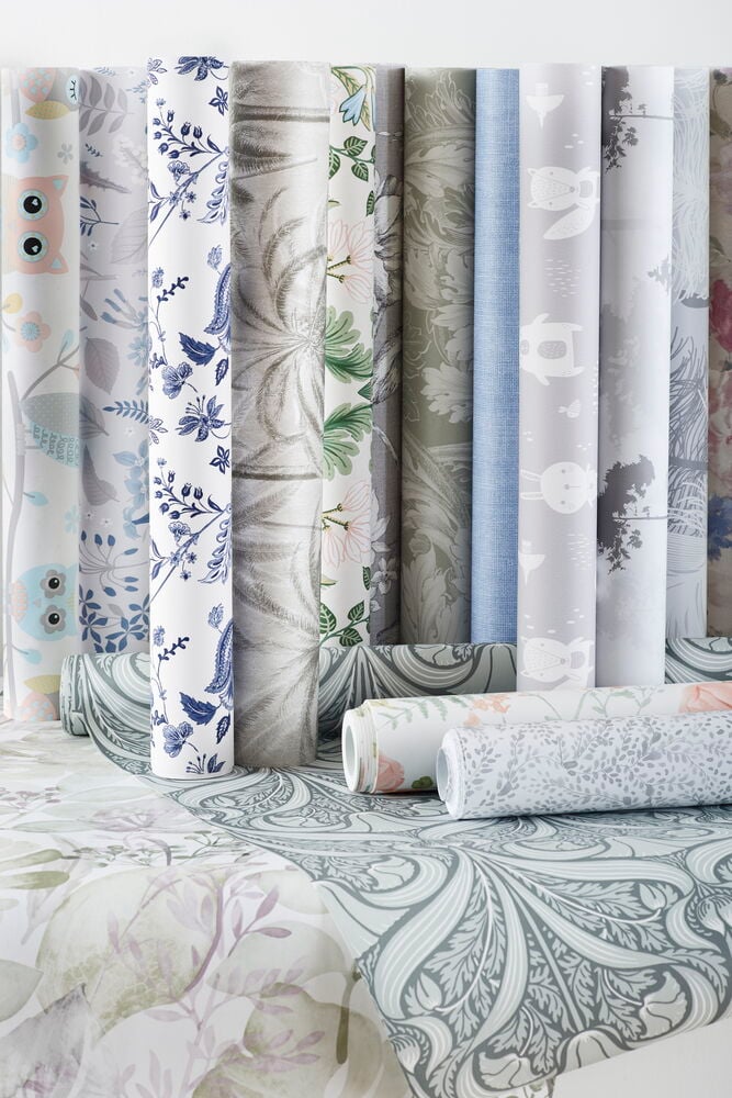 Tapete Classic 10x0,53 m Medallion Pastell Vlies, auf dem Boden ausgerollt, plus weitere Tapetenrollen.