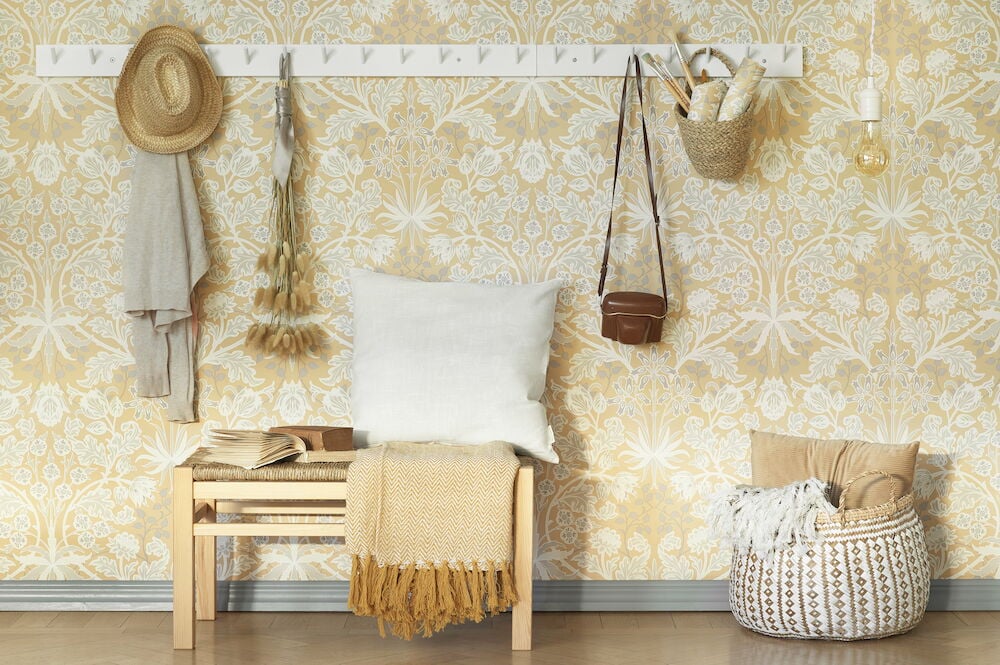 Gul tapet med viktorianskt blommönster och inredning.