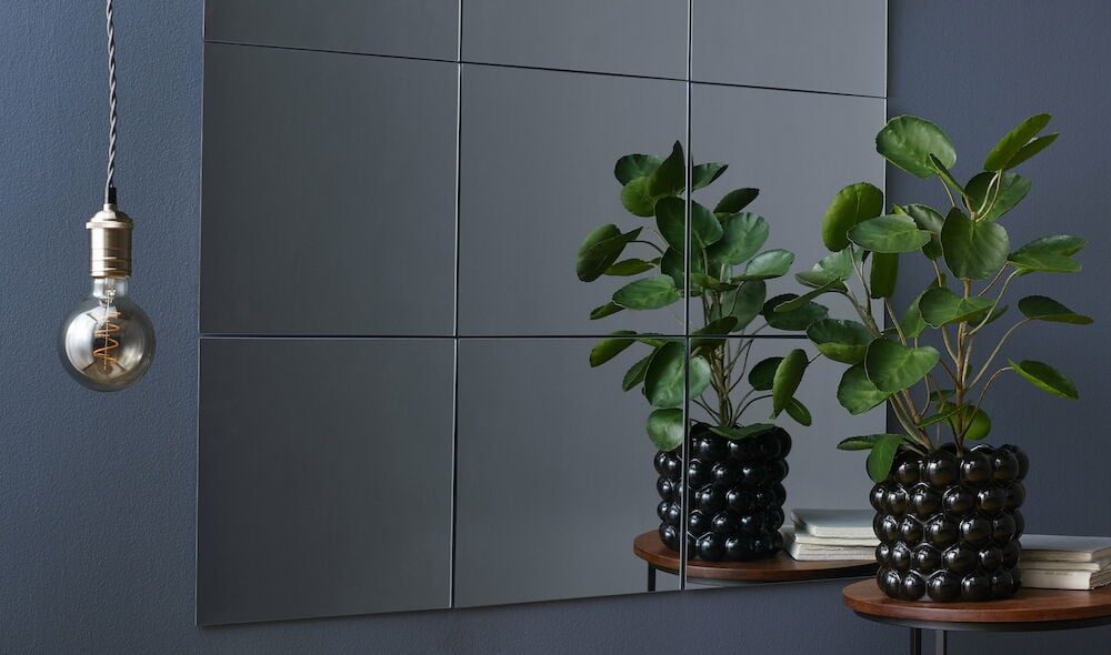 Mörkblå helmatt vägg med spegel och grön växt.