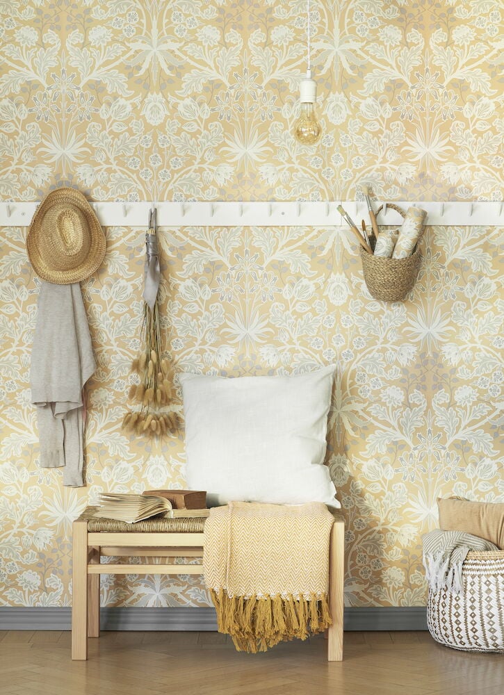 Gul tapet med viktorianskt blommönster i ett vardagsrum.