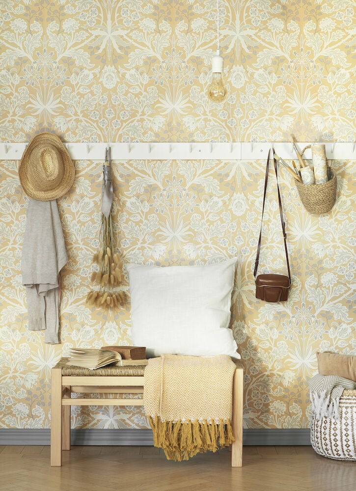 Gul tapet med viktorianskt blommönster och inredd hall.