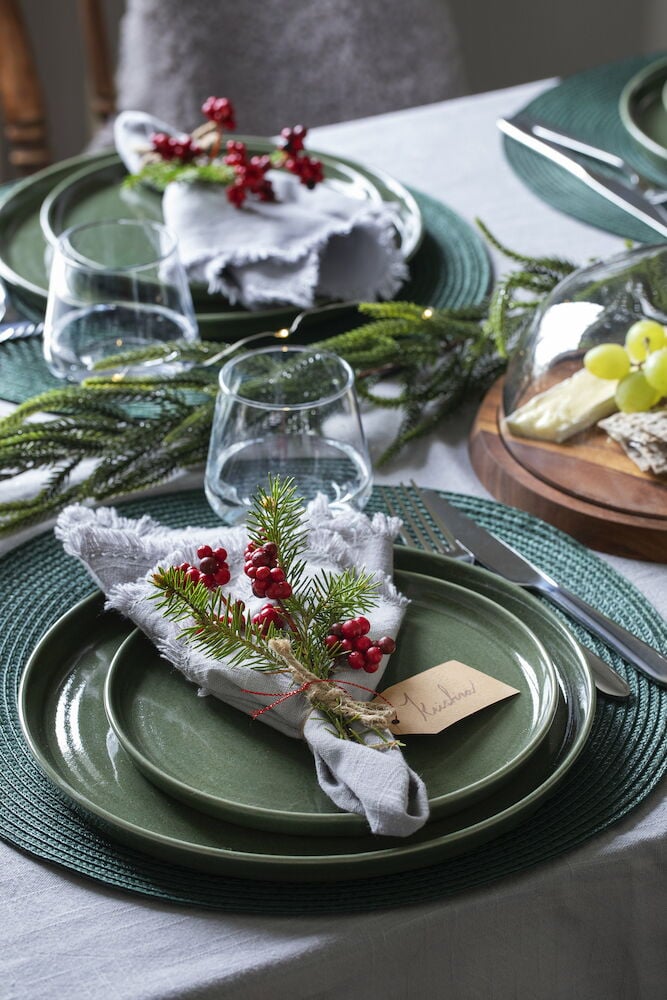 Hellgraue Baumwolltischdecke mit Fransen und Dekoration.