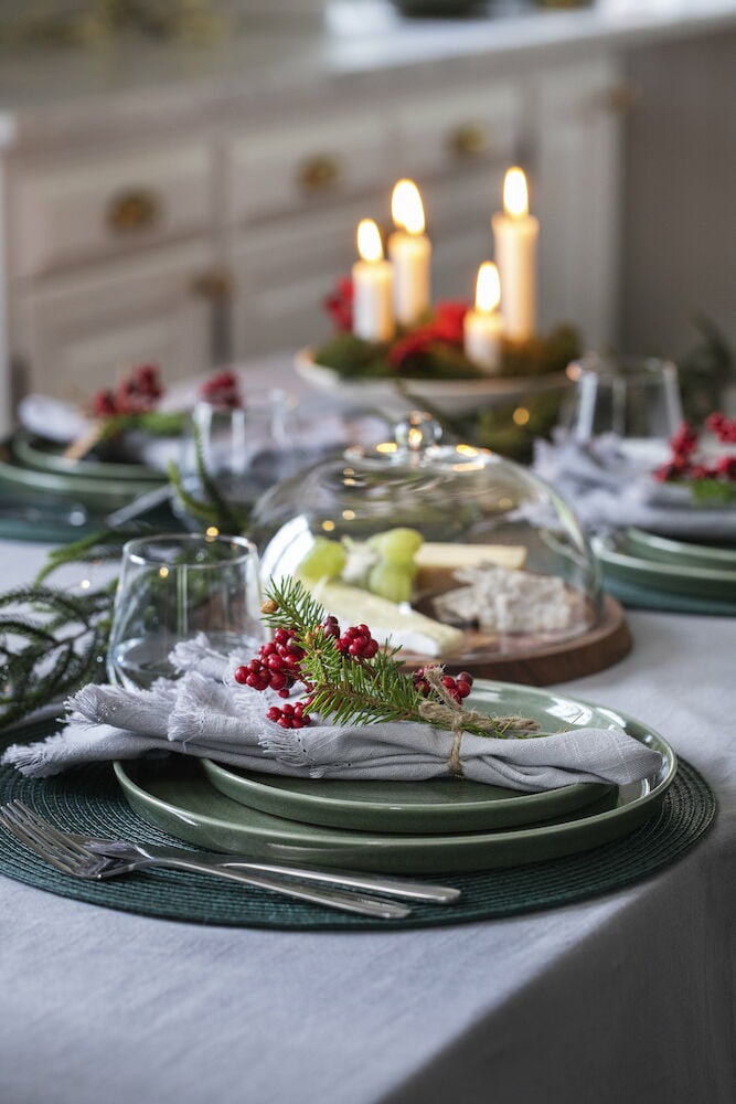 Hellgraue Baumwolltischdecke auf gedecktem Festtisch mit Dekoration.