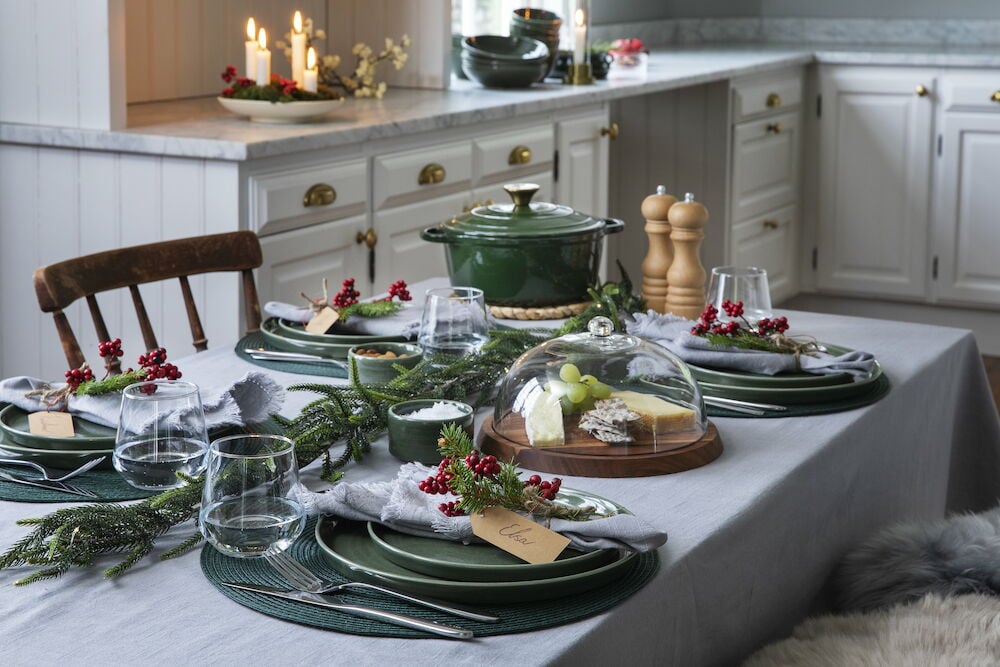 Gedeckter Esstisch mit hellgrauer Tischdecke und Dekoration.