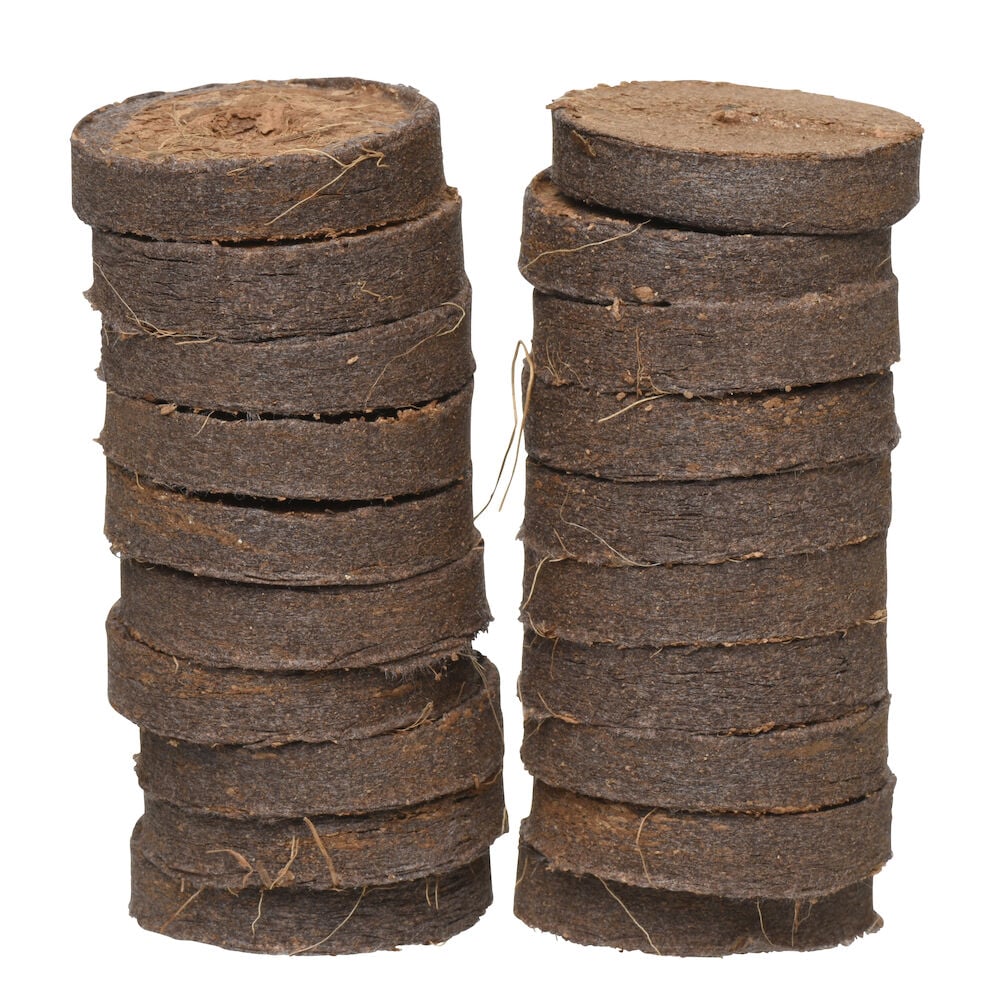 Zwei Stapel mit runden, braunen Anzuchttabletten.