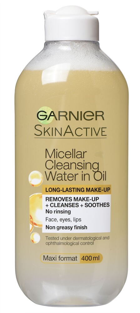 Läpinäkyvä pullo, jossa on keltaista puhdistusöljyä ja valkoinen korkki.