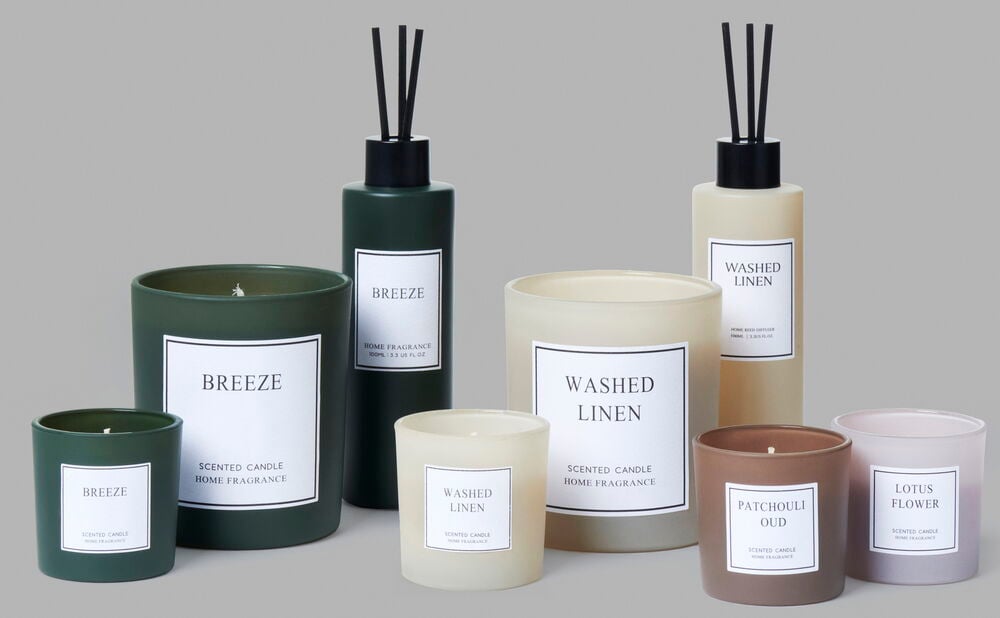 Beige doftljus i glas med etikett Washed Linen.