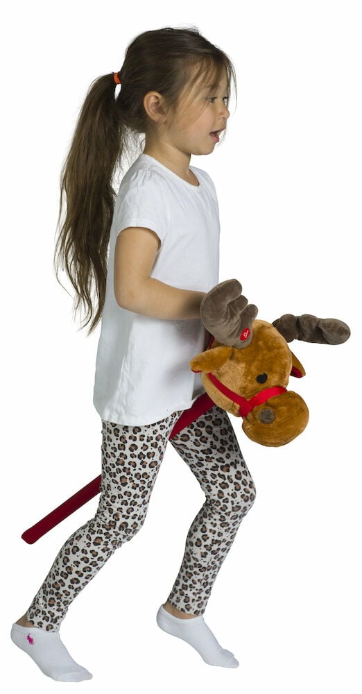 Tyttö leikkii keppihevosporolla sisätiloissa.