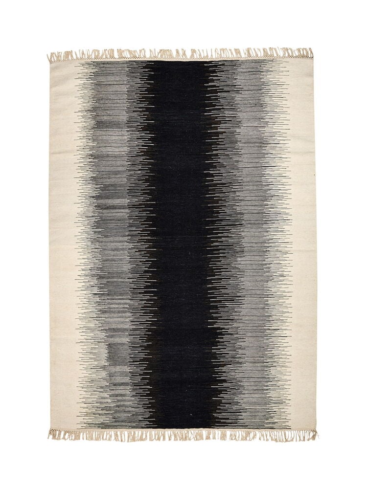 Käsin kudottu mustavalkoinen kelimmatto hapsuilla.