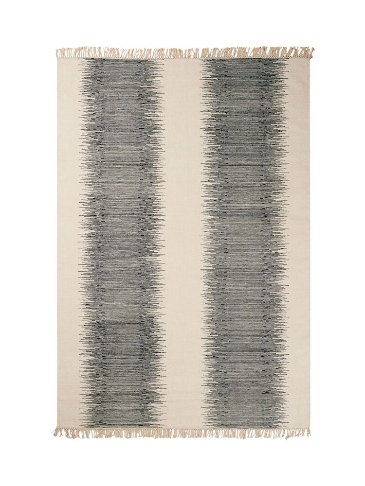 Käsinkudottu mustavalkoinen villamatto, jossa on hapsuja ja kuvioita.