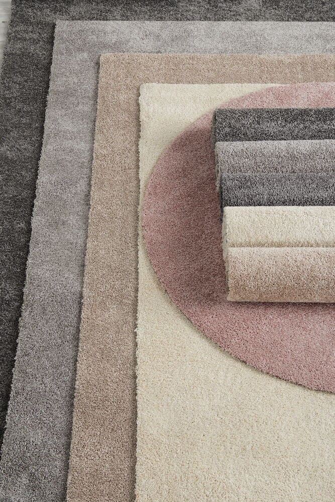Flera mattor i beige, grått och rosa ton.