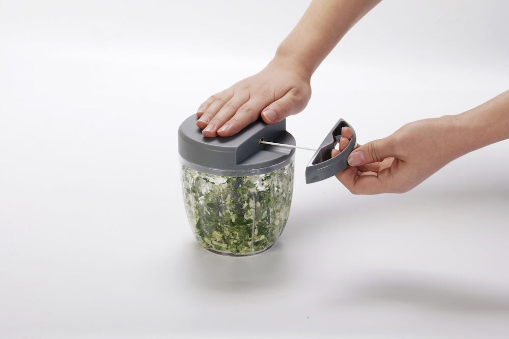 Manueller Minihacker mit grauem Deckel und Griff.