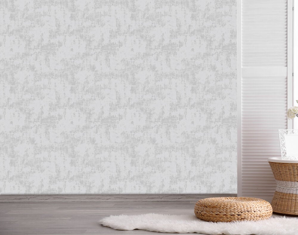 Harmaa yksivärinen tapetti seinällä rauhallisella sisustuksella.