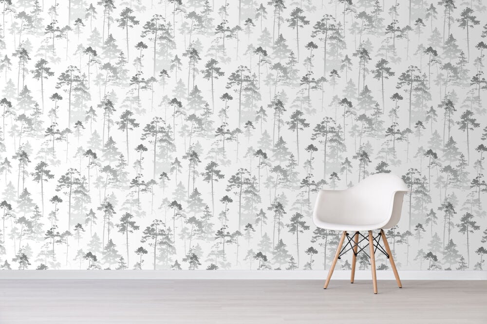 Gråhvit tapet med skogsmotiv og hvit stol.