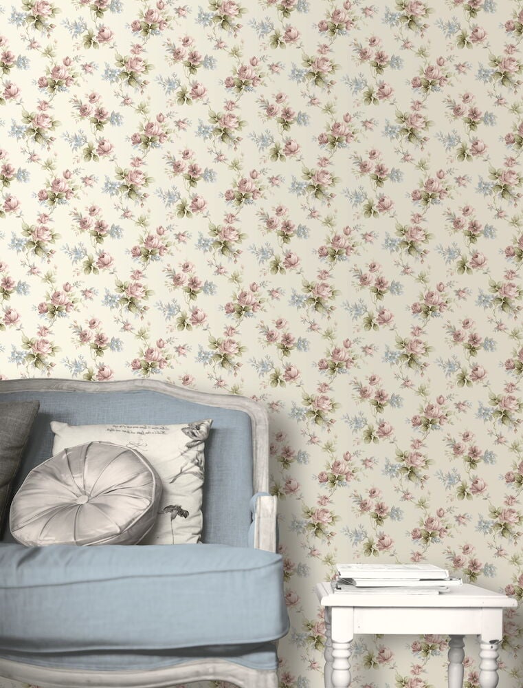 Blommig tapet i pastell bakom blå soffa.