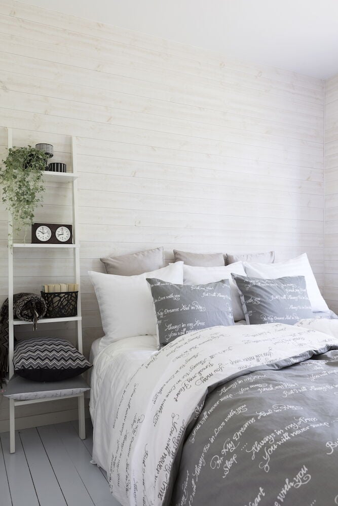 Harmaa puuvillainen pussilakanasetti, jossa on valkoinen kirjoituskuvio.