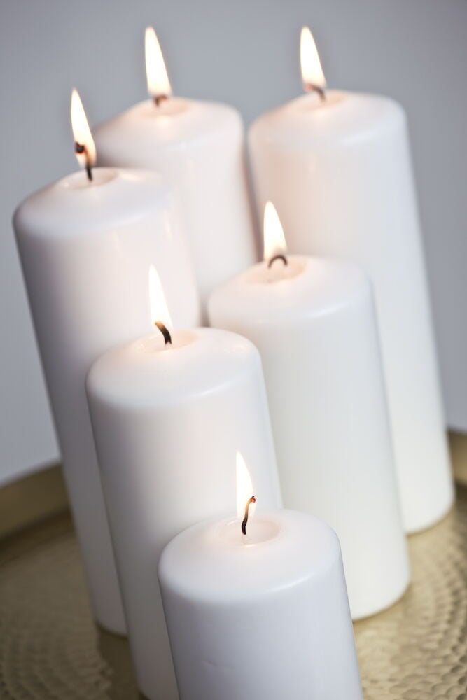 Sex vita blockljus står tätt tillsammans och brinner.