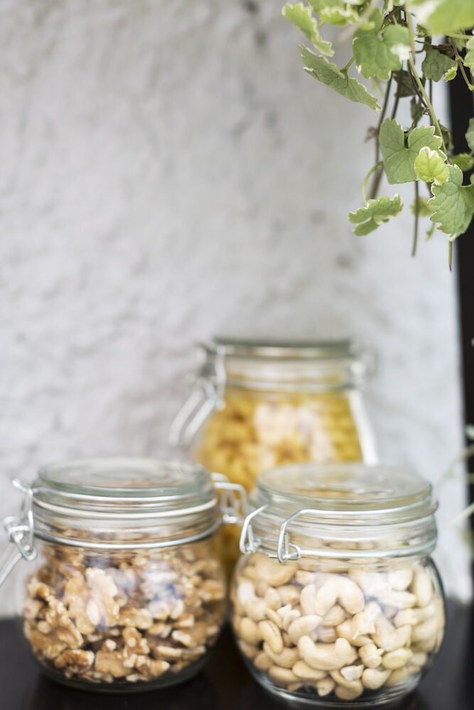 Tre glasburkar med lock fyllda med nötter.