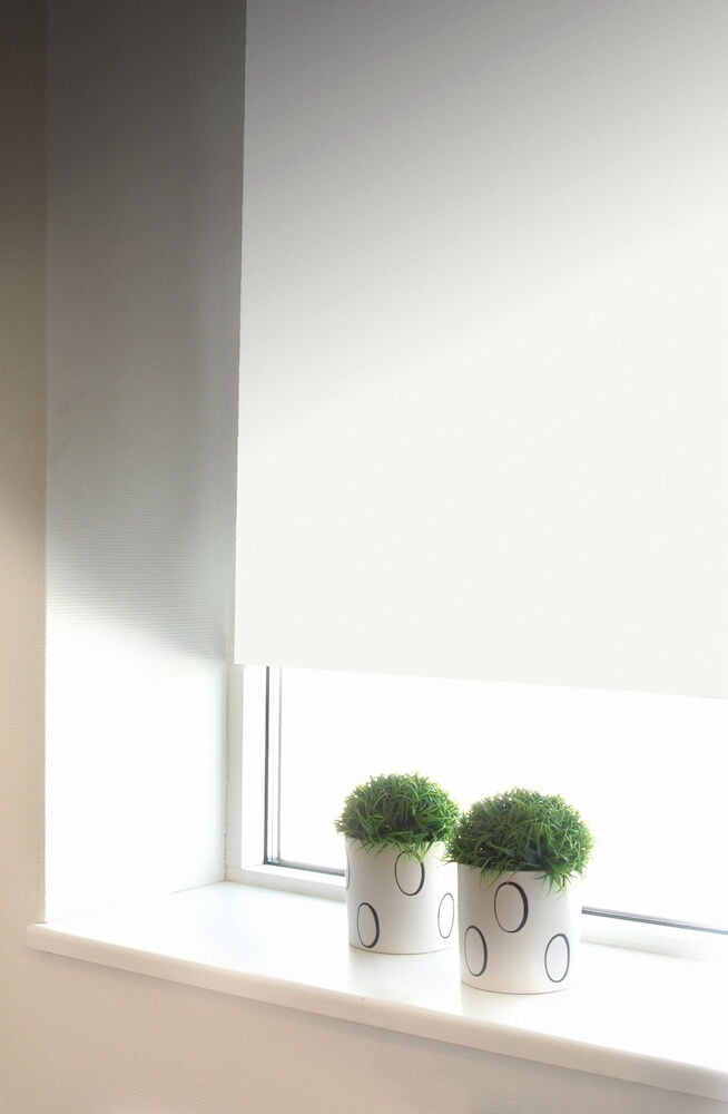 Valkoinen pimennysrullaverho ikkunalaudalla, jossa on ruukkukasveja.