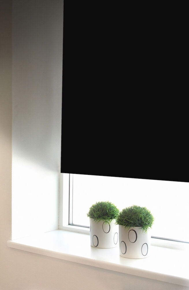 Musta pimennysrullaverho ikkunassa, jossa on ruukkukasveja.