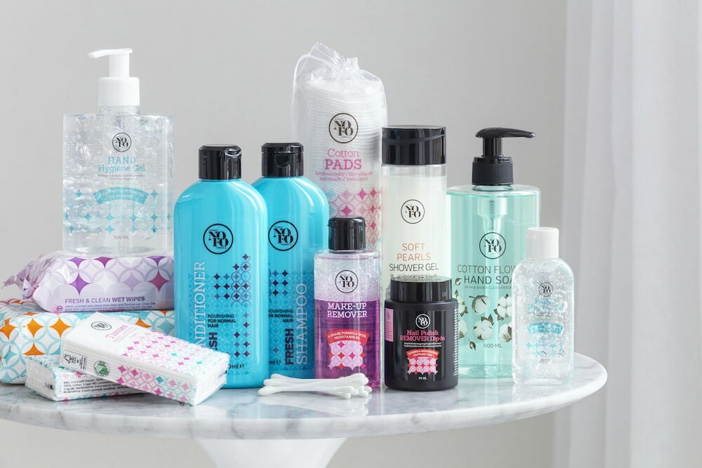 Förpackning bomullspinnar och andra hygienprodukter på bord.