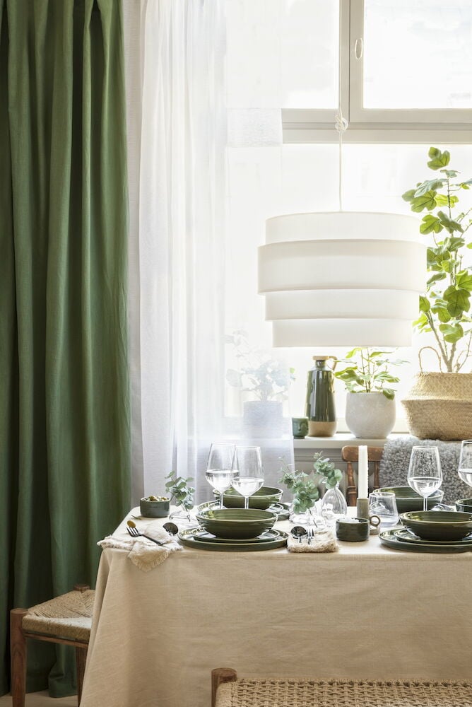 Beige pöytäliina, jossa on hapsut katetulla ruokapöydällä.