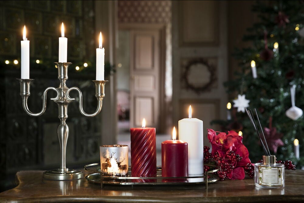 Vitt blockljus brinner på ett dekorerat bord.