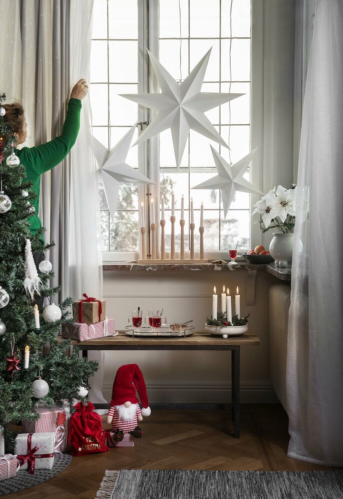 Vita gardinlängder framför fönster i vardagsrum.