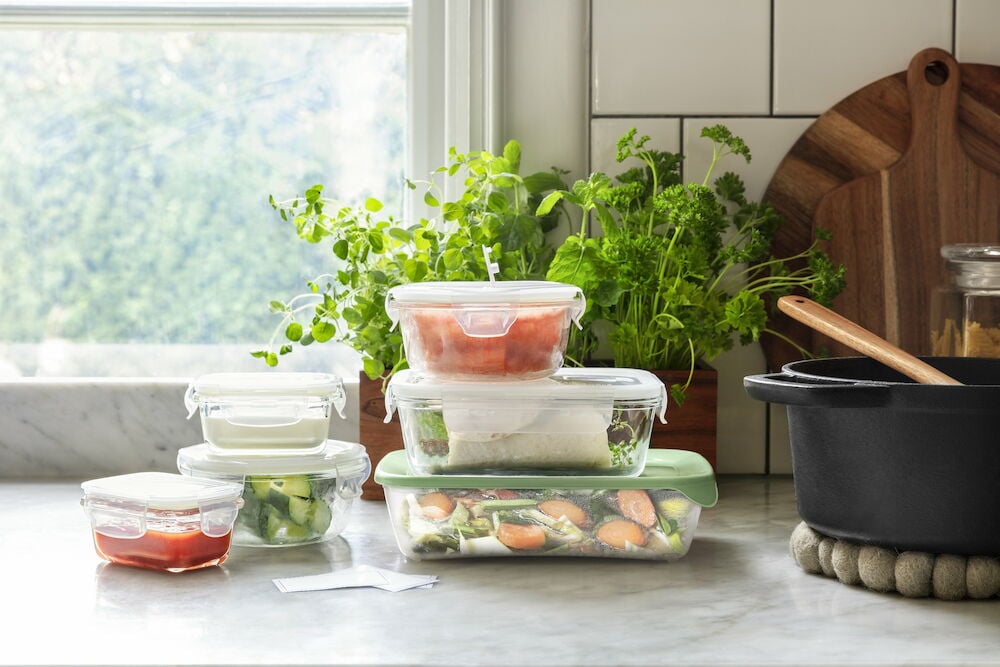 Flera glasmatlådor med plastlock på köksbänk.